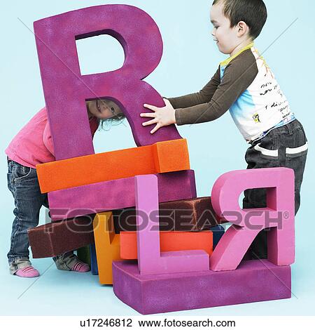 Toddlers playing with oversize letters View Large Photo Image Stock Image - Toddlers playing with oversize letters. Fotosearch