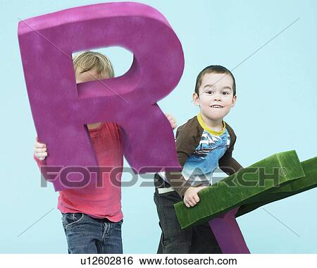 Toddlers playing with oversize letters View Large Photo Image Stock Photograph - Toddlers playing with oversize letters. Fotosearch