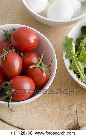 Stock Photo - Tomatoes, greens and mozzarella in bowls. Fotosearch