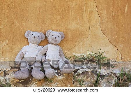 Stock Photo - Toy bears sitting on wall outdoors. Fotosearch