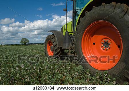 Picture - Tractor driving through crops. Fotosearch