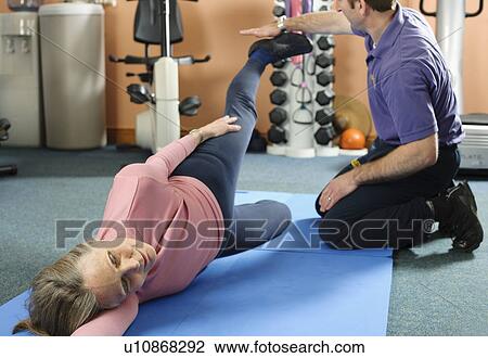 Trainer helping older woman exercise View Large Photo Image Stock Image - Trainer helping older woman exercise. Fotosearch