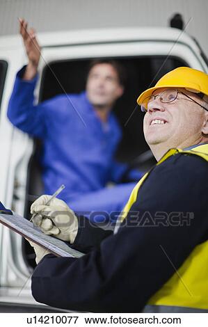 Stock Photo - Truck driver talking to worker. Fotosearch