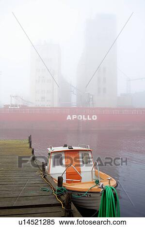 Stock Photography - Tugboat docked in urban bay. Fotosearch