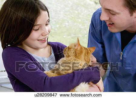 Vet talking to girl with her cat View Large Photo Image Stock Photo - Vet talking to girl with her cat. Fotosearch