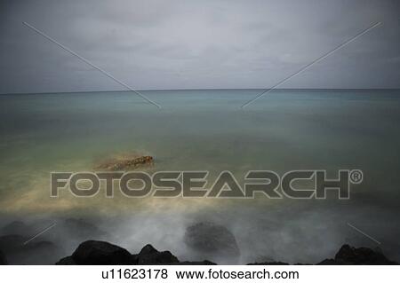 Waves and fog over rocks on beach View Large Photo Image Stock Photo - Waves and fog over rocks on beach. Fotosearch