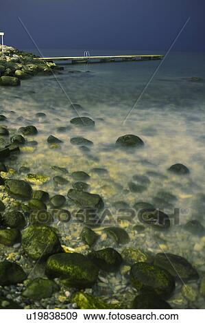 Waves and fog over rocks on beach View Large Photo Image Stock Photo - Waves and fog over rocks on beach. Fotosearch