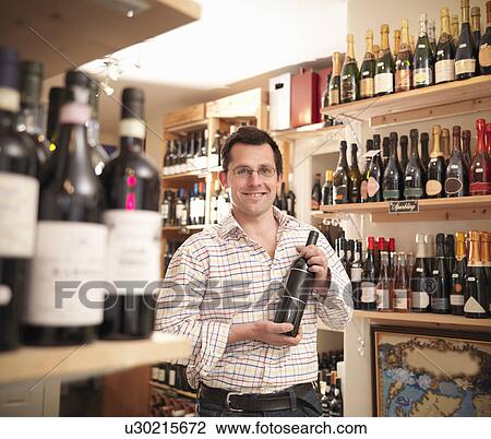 Wine merchant with wine bottle in shop View Large Photo Image Stock Image - Wine merchant with wine bottle in shop. Fotosearch