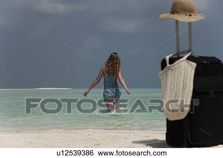 Woman abandoning luggage on beach View Large Photo Image Stock Photograph - Woman abandoning luggage on beach. Fotosearch