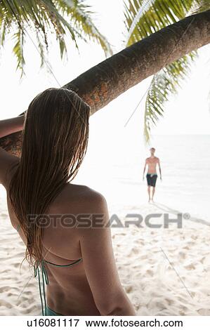 Woman admiring man on tropical beach View Large Photo Image Stock Photo - Woman admiring man on tropical beach. Fotosearch