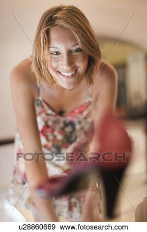 Stock Photo - Woman admiring shoe in window. Fotosearch