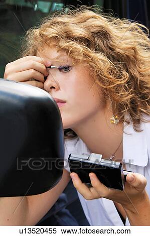 Woman applying makeup in car mirror View Large Photo Image Stock Photography - Woman applying makeup in car mirror. Fotosearch