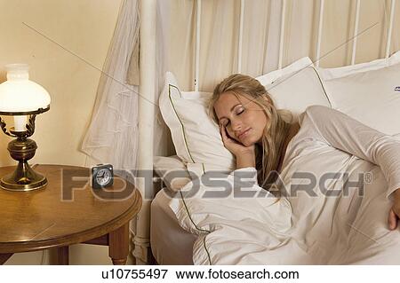 Woman asleep in bed by alarm clock View Large Photo Image Stock Photo - Woman asleep in bed by alarm clock. Fotosearch