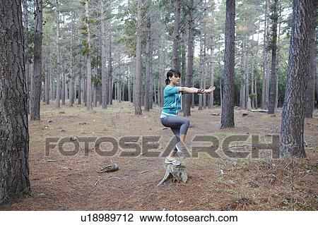 Woman balancing on stump in forest View Large Photo Image Stock Image - Woman balancing on stump in forest. Fotosearch