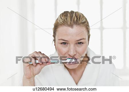 Woman brushing her teeth in bathroom View Large Photo Image Picture - Woman brushing her teeth in bathroom. Fotosearch