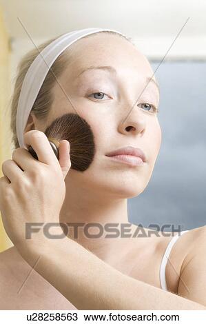 Woman brushing powder onto her face View Large Photo Image Stock Image - Woman brushing powder onto her face. Fotosearch