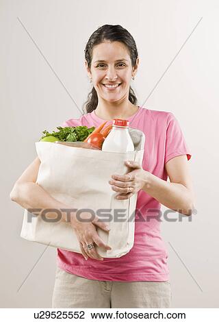 Woman carrying bag of groceries View Large Photo Image Stock Image - Woman carrying bag of groceries. Fotosearch