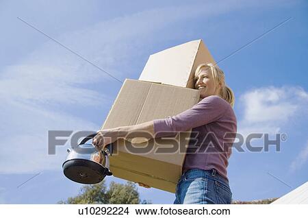 Picture - Woman carrying cardboard boxes. Fotosearch