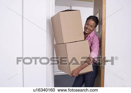 Woman carrying cardboard boxes View Large Photo Image Stock Image - Woman carrying cardboard boxes. Fotosearch