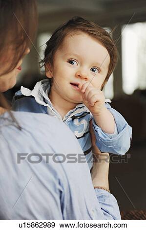 Woman carrying toddler son View Large Photo Image Stock Photo - Woman carrying toddler son. Fotosearch