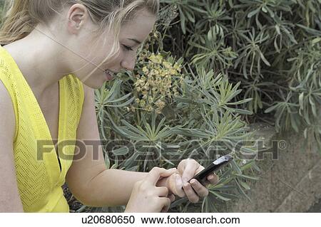 Stock Image - Woman checking her pulse in park. Fotosearch