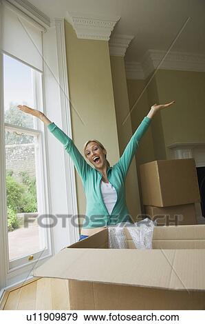 Woman cheering in new home View Large Photo Image Stock Photo - Woman cheering in new home. Fotosearch