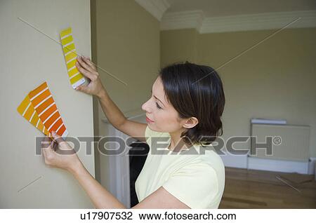 Woman choosing paint color in new home View Large Photo Image Stock Image - Woman choosing paint color in new home. Fotosearch