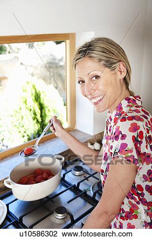 Woman cooking in kitchen View Large Photo Image Stock Image - Woman cooking in kitchen. Fotosearch