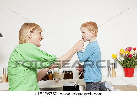 Woman cooking with son in kitchen View Large Photo Image Stock Image - Woman cooking with son in kitchen. Fotosearch