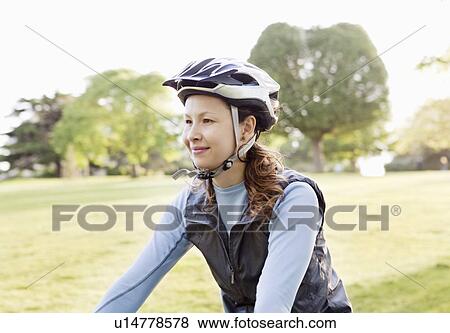 Woman cycling at park View Large Photo Image Stock Photo - Woman cycling at park. Fotosearch