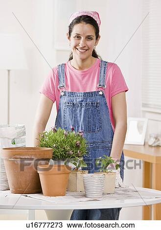 Woman depotting plants at home View Large Photo Image Stock Image - Woman depotting plants at home. Fotosearch