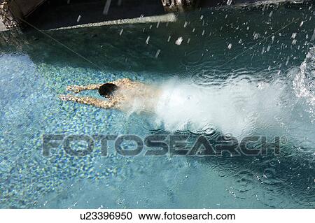 Stock Image - Woman diving into swimming pool. Fotosearch