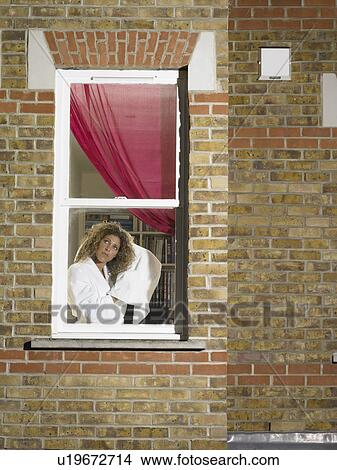 Woman drying her hair in window View Large Photo Image Picture - Woman drying her hair in window. Fotosearch