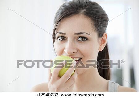 Stock Image - Woman eating an apple. Fotosearch