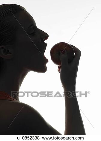 Woman eating an apple View Large Photo Image Stock Photo - Woman eating an apple. Fotosearch