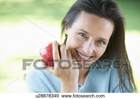 Woman eating an apple View Large Photo Image Stock Photo - Woman eating an apple. Fotosearch