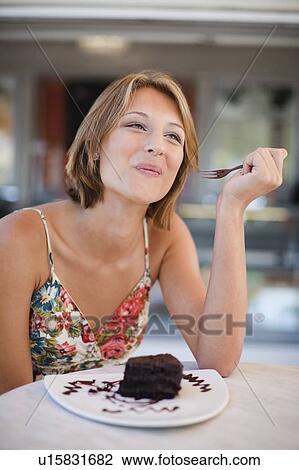 Woman eating dessert at cafe View Large Photo Image Stock Image - Woman eating dessert at cafe. Fotosearch