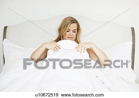 Woman examining herself under duvet View Large Photo Image Stock Photo - Woman examining herself under duvet. Fotosearch