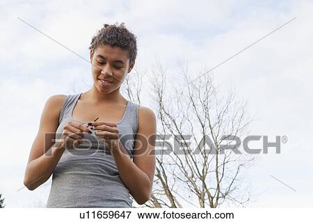 Stock Photo - Woman examining twig outdoors. Fotosearch