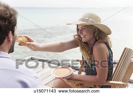 Woman feeding boyfriend on deck View Large Photo Image Stock Image - Woman feeding boyfriend on deck. Fotosearch