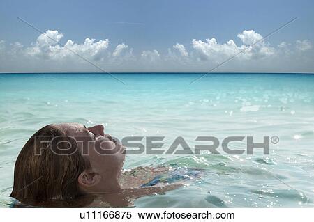 Woman floating in calm sea View Large Photo Image Stock Photography - Woman floating in calm sea. Fotosearch