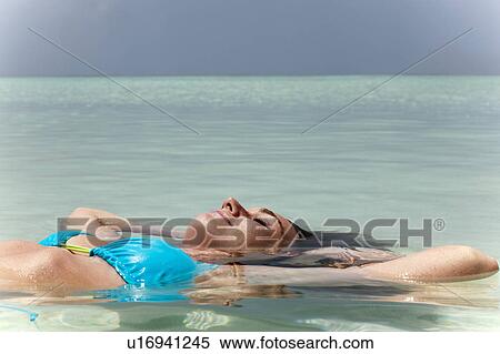 Woman floating in tropical sea View Large Photo Image Stock Photography - Woman floating in tropical sea. Fotosearch