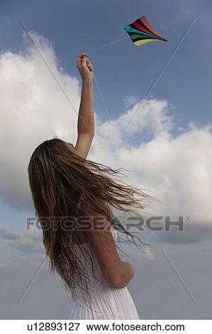 Stock Photo - Woman flying a kite. Fotosearch