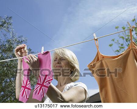 Stock Photo - Woman hanging socks on clothesline. Fotosearch