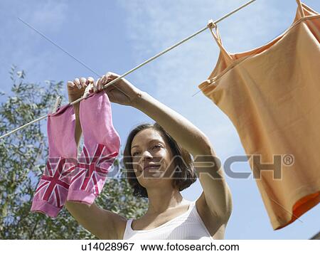 Woman hanging socks on clothesline View Large Photo Image Stock Photo - Woman hanging socks on clothesline. Fotosearch