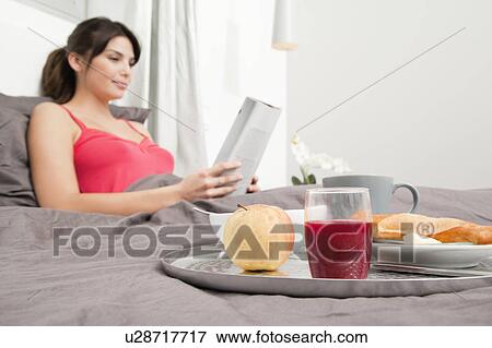 Stock Photo - Woman having breakfast in bed. Fotosearch