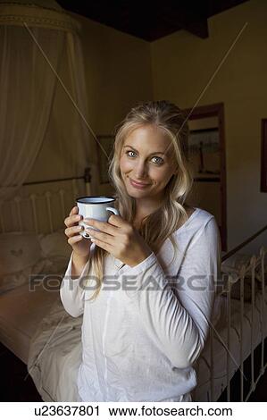 Woman having cup of coffee in bedroom View Large Photo Image Stock Image - Woman having cup of coffee in bedroom. Fotosearch