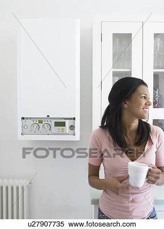 Stock Photography - Woman having cup of coffee in kitchen. Fotosearch