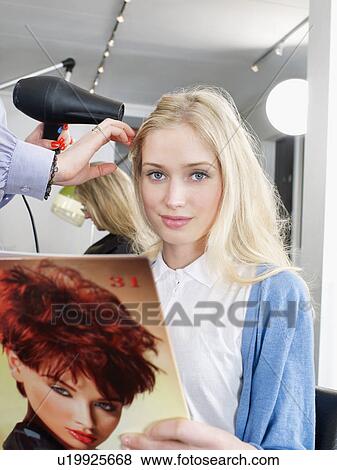 Woman having hair dried in salon View Large Photo Image Stock Photo - Woman having hair dried in salon. Fotosearch