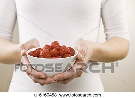 Woman holding bowl of raspberries View Large Photo Image Stock Photo - Woman holding bowl of raspberries. Fotosearch